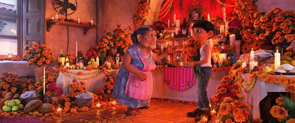 Coco Miguel and Abuelita standing by day of the dead shrine