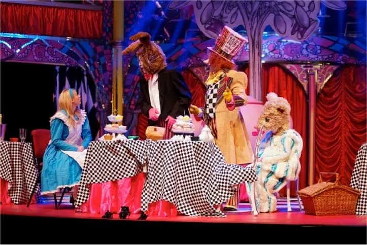 Alice In Wonderland musical Alice having dinner with friends