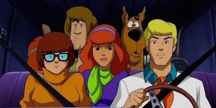 Fred driving with Velma, Daphne, Scooby, and Shaggy