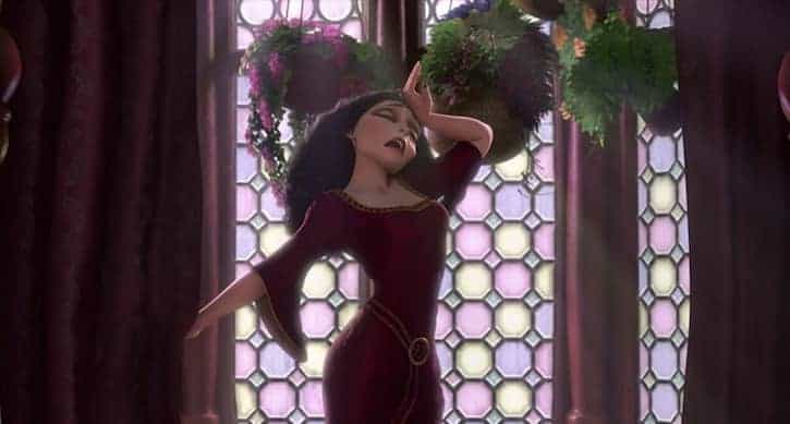 Mother Gothel in her purple dress with her wrist held to her forehead