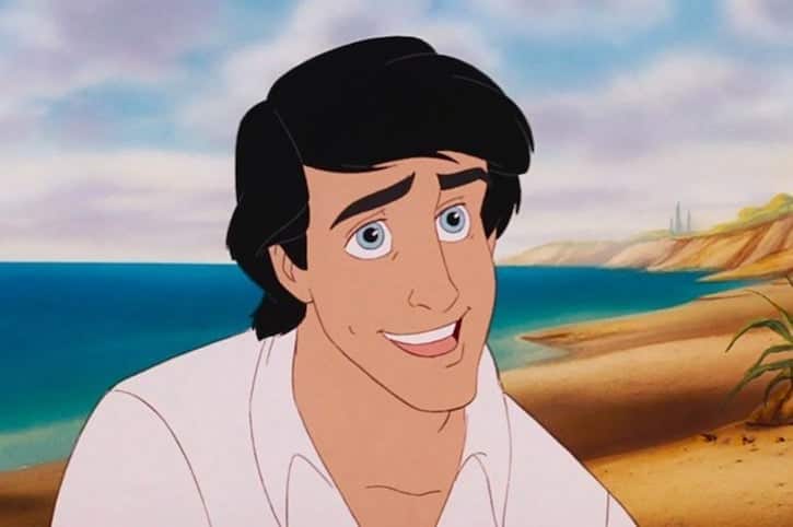Prince Eric smiling on the beach with short black hair and blue eyes