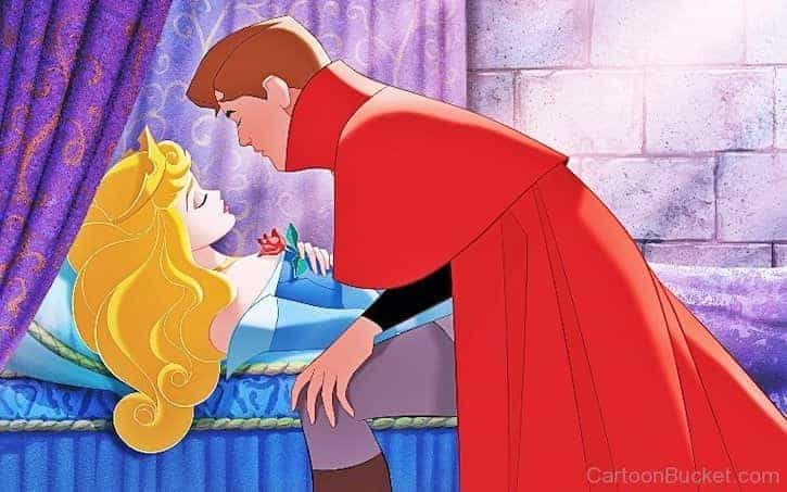 Prince Phillip leaning in to kiss Princess Aurora while she lays asleep
