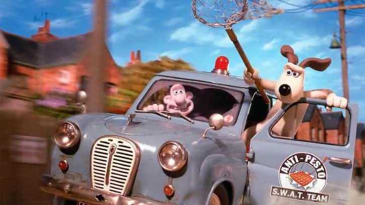 Wallace and Gromit driving a blue truck trying to catch rabbits with a net