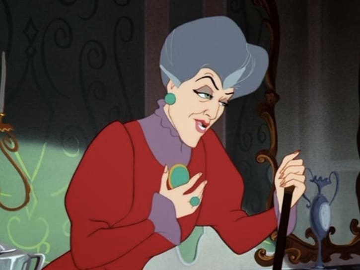 Lady Tremaine leaning on her cane with her right hand on over her heart