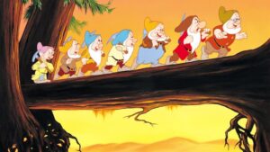 The seven dwarfs walking across a log at sunset