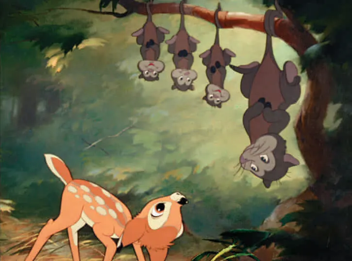 Bambi looking up at a family of possums hanging upside down from a tree branch