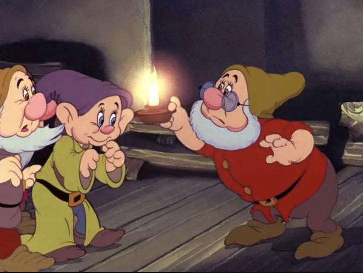 Doc holding a candle inside the dwarfs cottage