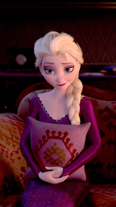 Elsa sitting down and holding a pillow