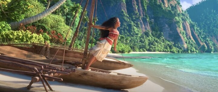 Moana at the edge of her raft in the sand singing