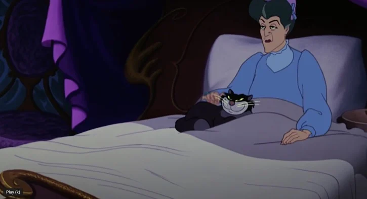 Lady Tremaine petting Lucifer her cat as she sits up in bed